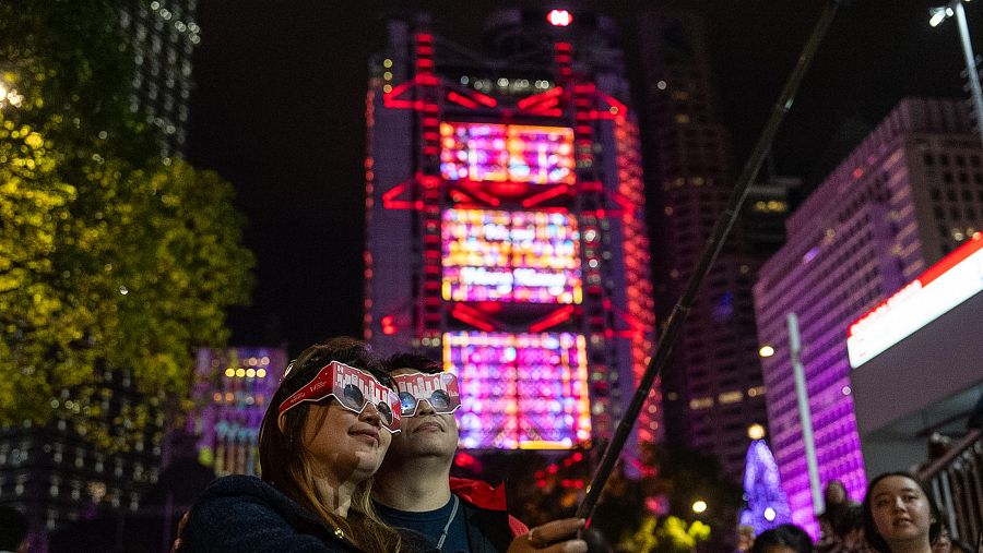 Una pareja se hace un selfi recibiendo el nuevo año en el distrito central de Hong Kong.