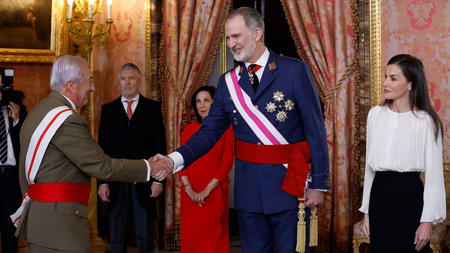 El rey Felipe VI y la reina Letizia saludan a un alto mando militar en el Salón del Trono del Palacio Real en el marco de la ceremonia de la Pascua Militar.