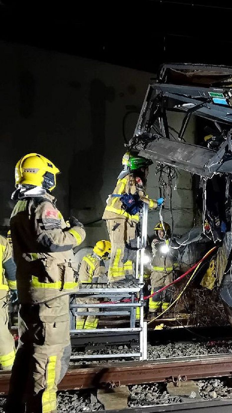 Los Bomberos de la Generalitat trabajan en el lugar del accidente de un tren de la línea 4 de Rodalies
