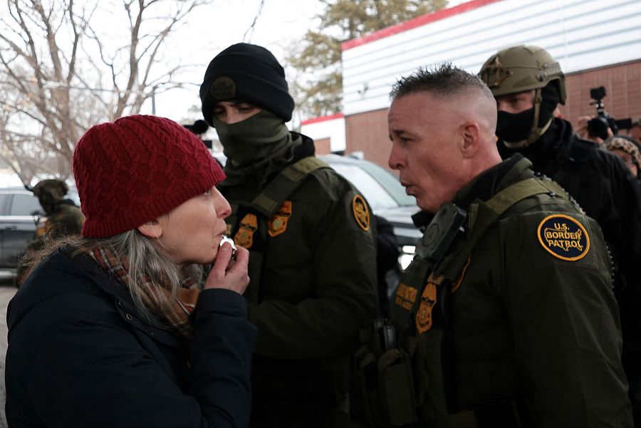 Una mujer hace sonar un silbato frente al comandante de la Patrulla Fronteriza, Greg Bovino, en Minneapolis, Minnesota