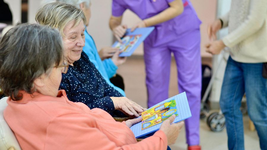 Trini y Santi jugando al bingo de figuras en la residencia Aedes de Zaragoza
