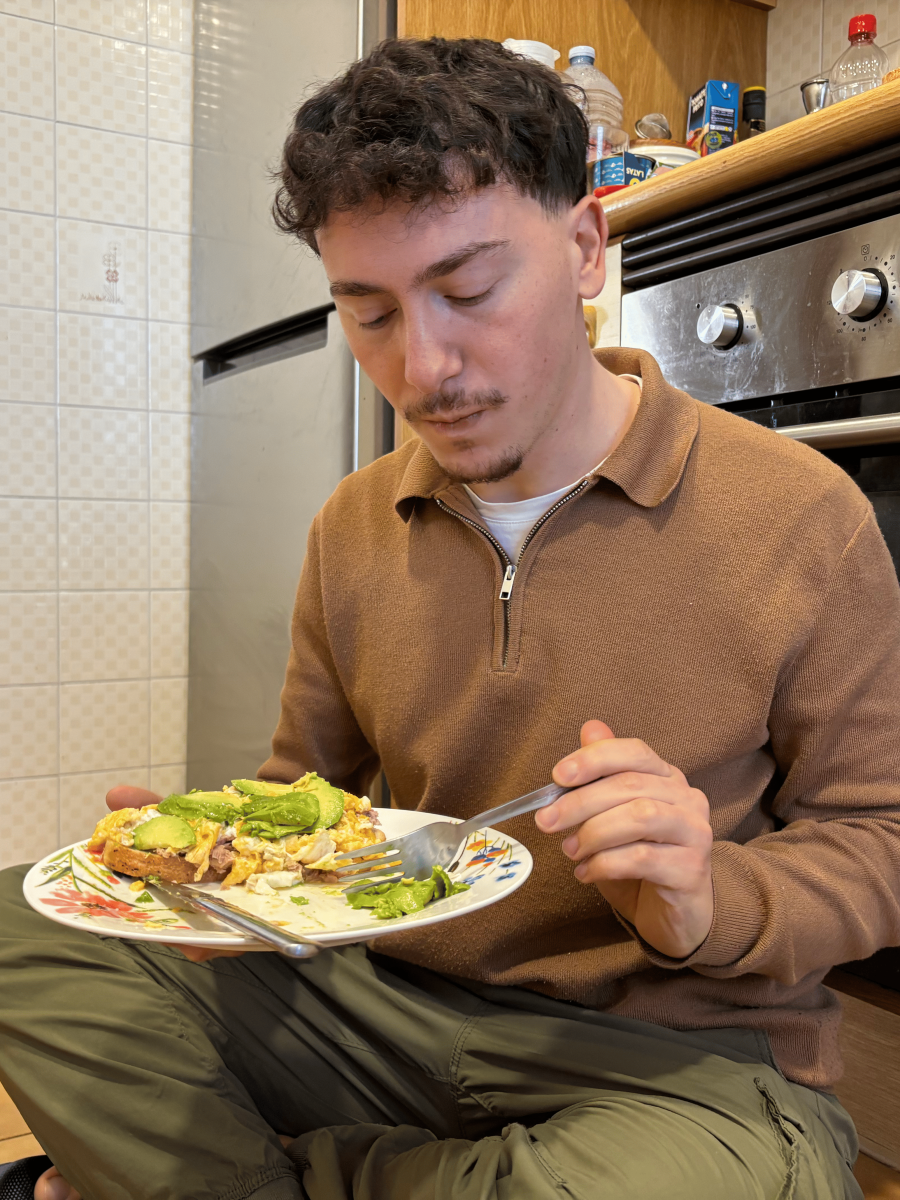 Joven comiendo sentado en la cocina