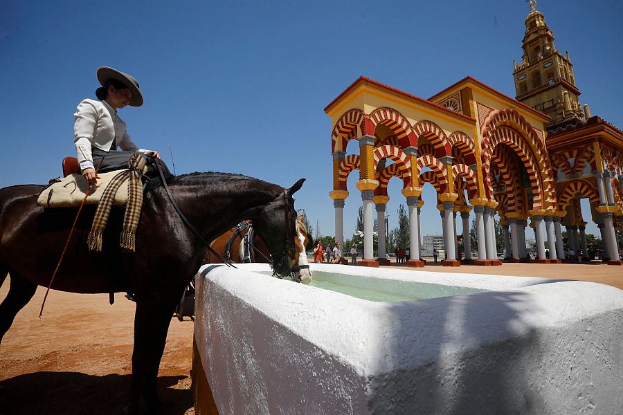 Jinete vestida con el traje cordobés por el recinto ferial de El Arenal en Córdoba