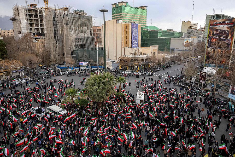 Manifestantes se congregan con banderas nacionales iraníes durante una manifestación en apoyo al gobierno y contra los ataques estadounidenses e israelíes frente a una mezquita en Teherán