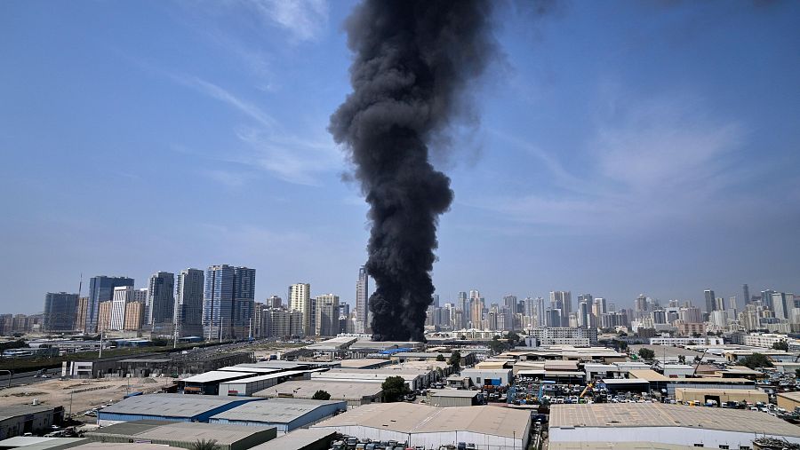 Una columna de humo negro se eleva desde un almacén en la zona industrial de la ciudad de Sharjah, en los Emiratos Árabes Unidos
