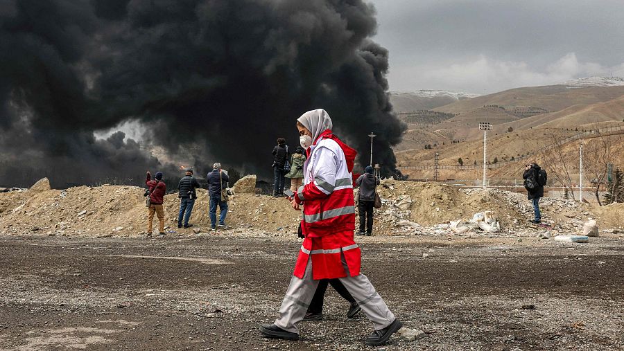 Varias personas se protegen de la nube tóxica en Teherán