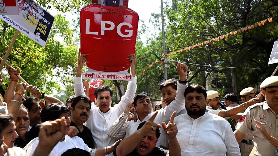 Una protesta en Nueva Delhi muestra a manifestantes con pancartas y un gran cartel en forma de bombona de gas roja, protestando contra el aumento de precio y la escasez de gas licuado de petróleo.