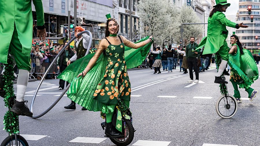 Un grupo de volatineros, equilibristas en monociclo, desfila por la Gran Vía madrileña para celebrar el día de San Patricio.