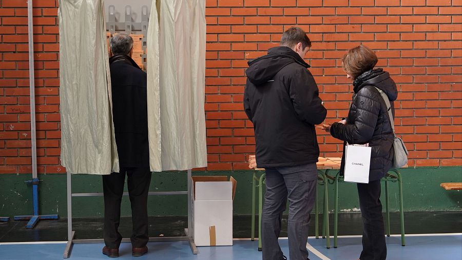 Un hombre entra en una cabina para introducir su voto en la papeleta