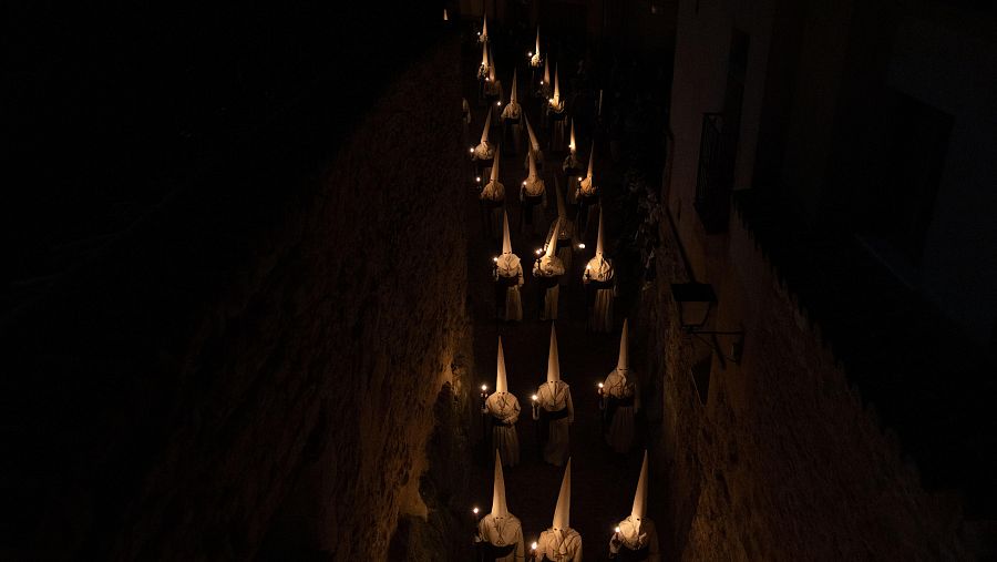 Penitentes de la cofradía del Jesús Yacente participan en una procesión religiosa durante la Semana Santa en Zamora