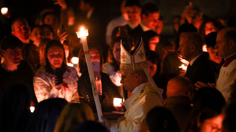 El pontífice procesiona hacia el altar portando una vela encendida
