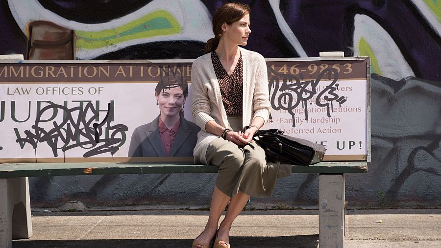 Judy Wood, sentada en un banco con publicidad sobre su despacho.