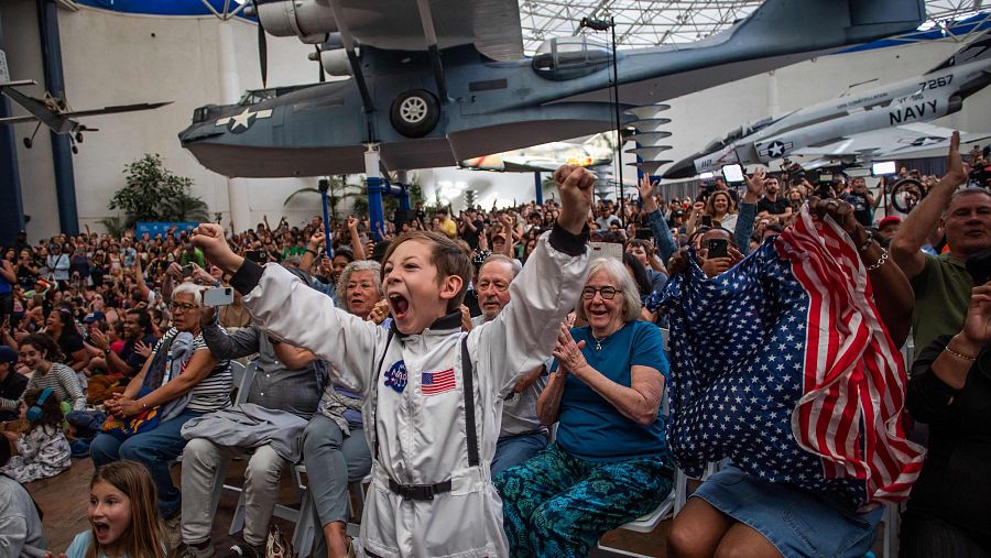 Un niño vestido con un disfraz de astronauta celebra la llegada a la Tierra de los miembros de la tripulación de Artemis II