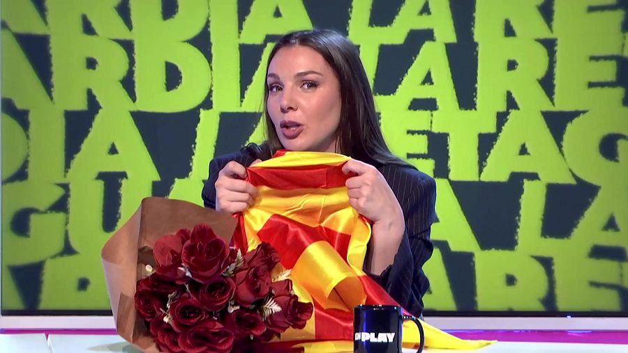 Cristina Pardo con bandera de España, rosas rojas y taza 