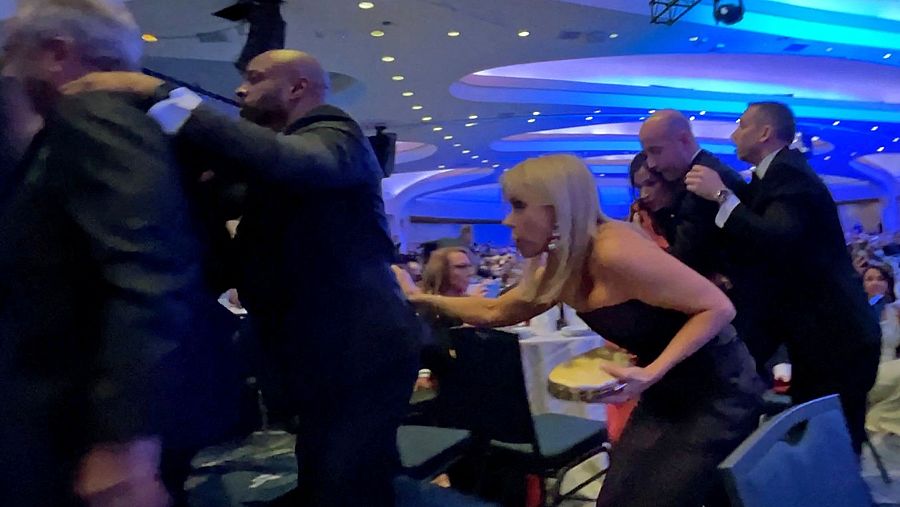 Momento en el que varios asistentes de la cena buscan refugio tras el tiroteo