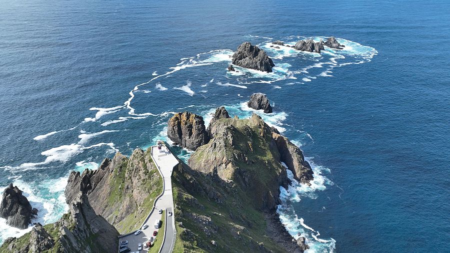 Vista aérea del faro de Cabo Ortegal, en Galicia, rodeado por formaciones rocosas y el intenso oleaje del Atlántico.