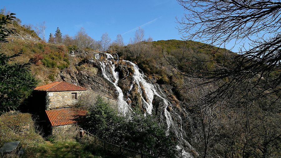 La Fervenza das Brañas desciende entre rocas y vegetación, mostrando la fuerza y belleza de los paisajes interiores de Galicia.