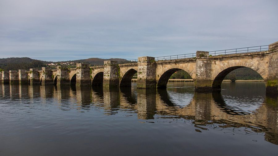 El puente medieval de Nafonso, sobre el río Tambre, refleja siglos de historia en sus arcos de piedra.