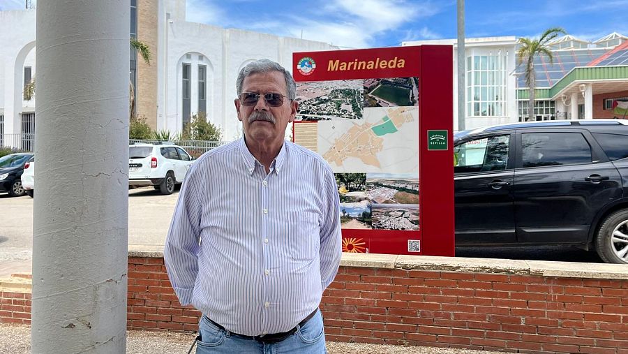 Eduardo, vecino de Marinaleda, delante de uno de los carteles informativos del municipio.