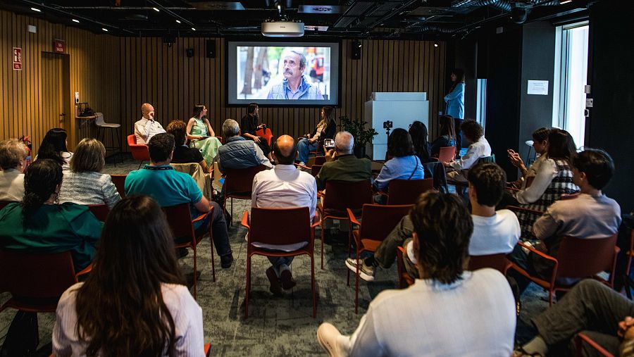 Una sala llena de gente sentada mira la proyeccion de un vídeo en las oficinas de Google España