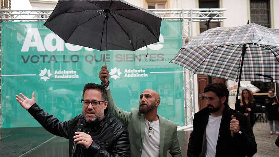 El candidato por Adelante Andalucía, José Ignacio García, dirige unas palabras al publico asistente tras suspenderse el acto de campaña este sábado, en Málaga, por la lluvia.