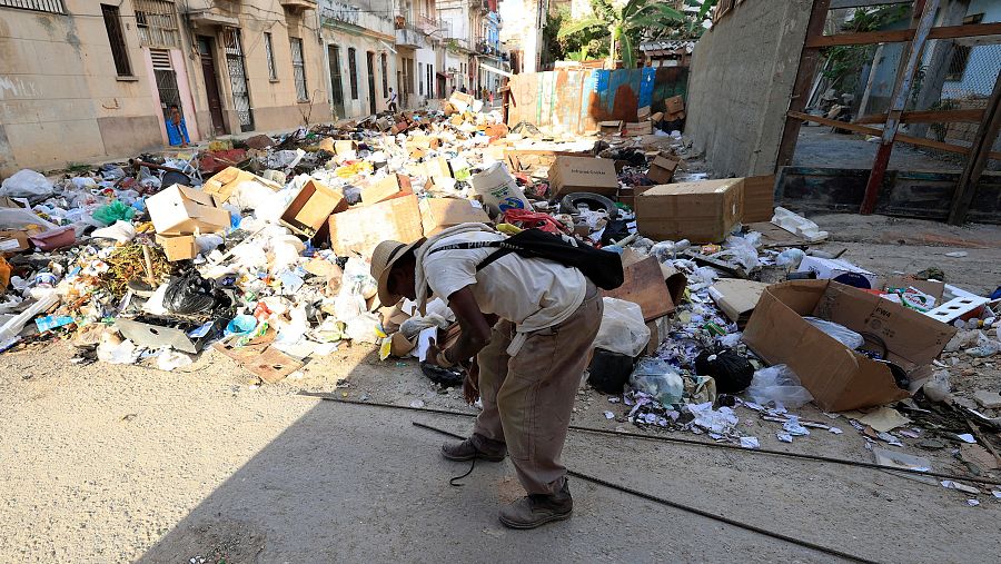 Una persona camina frente a una calle llena de basura este jueves, en La Habana (Cuba)