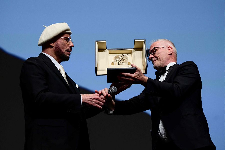 Momento en el que John Travolta recibe sorprendido la Palma de Oro de Honor del Festival de Cannes