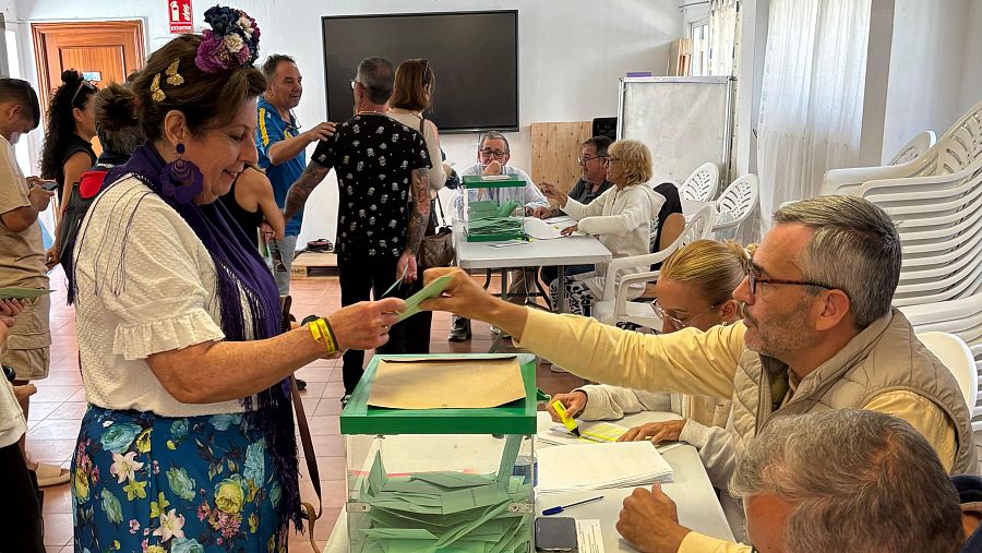 Una mujer vestida con falda rociera ejerce su derecho al voto en el municipio de Vélez-Málaga, durante las elecciones de Andalucía