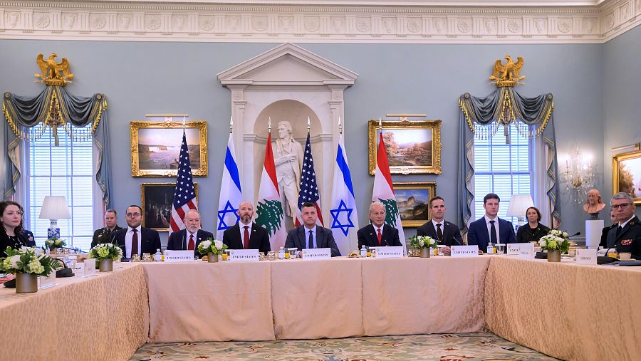 Reunión diplomática entre Líbano, Estados Unidos e Israel en una sala formal con banderas y delegaciones sentadas alrededor de una mesa.
