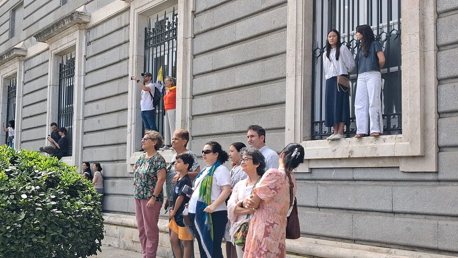 Personas esperando la llegada de León XIV frente al Palacio Real