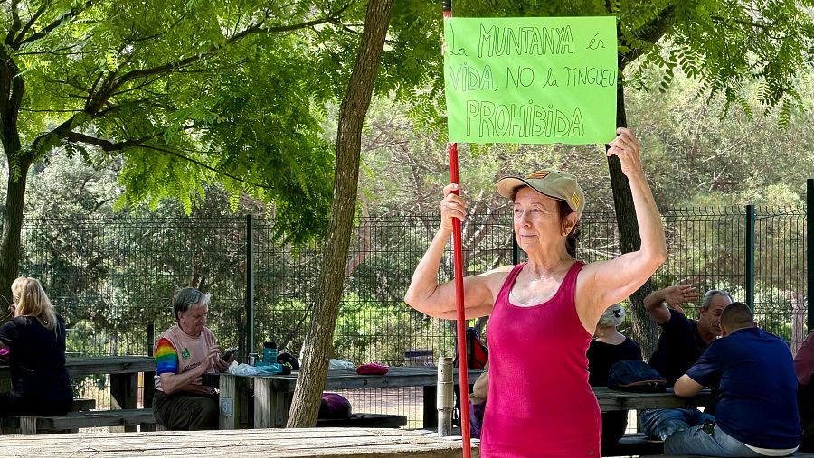 Una dona sosté un cartell després de la caminada reivindicativa a Collserola