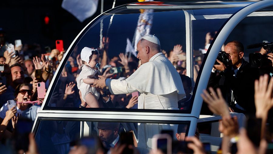 El papa León XIV hace alguna parada para acercarse a varios bebés en su recorrido por Madrid en el papamóvil para dirigirse a la Plaza de Lima