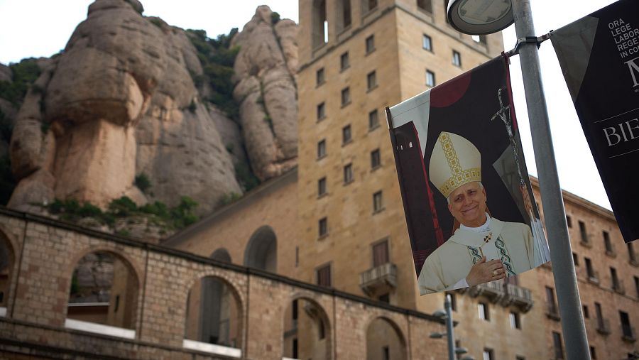 Una pancarta con la imagen del papa León XIV cuelga de una farola en la plaza principal del Monasterio de Montserrat.