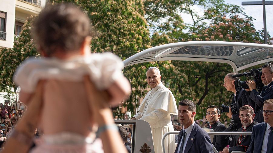 Unos padres ofrecen un bebe al papa, de camino al Movistar Arena, a 7 de junio de 2026 en Madrid