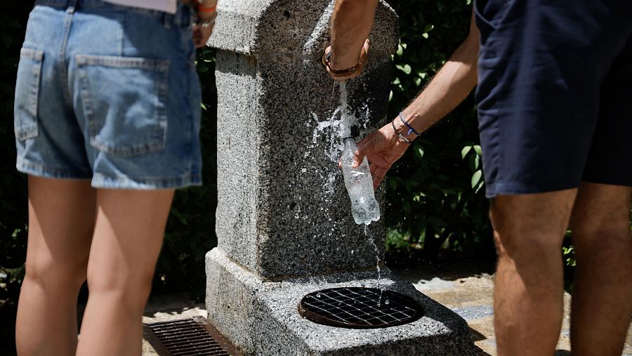 Dos personas cogen agua en una fuente del madrileño Parque del Retiro, este martes