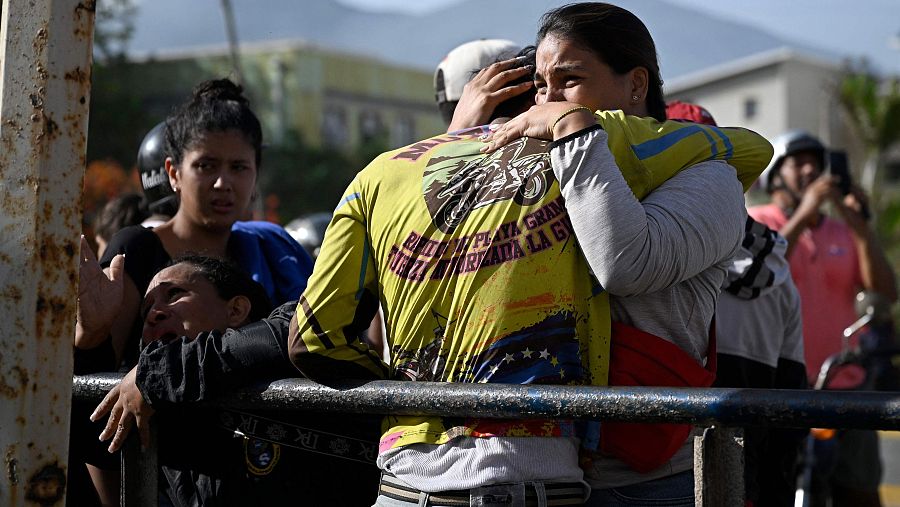 Un abrazo conmovedor en medio del dolor, con una camiseta amarilla que dice 