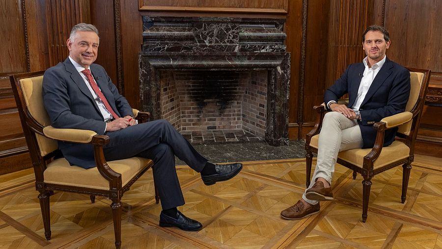 Jenaro Castro y Albert Rivera, sentados en sillones clásicos, posan sonrientes en un salón con chimenea de mármol y paneles de madera.