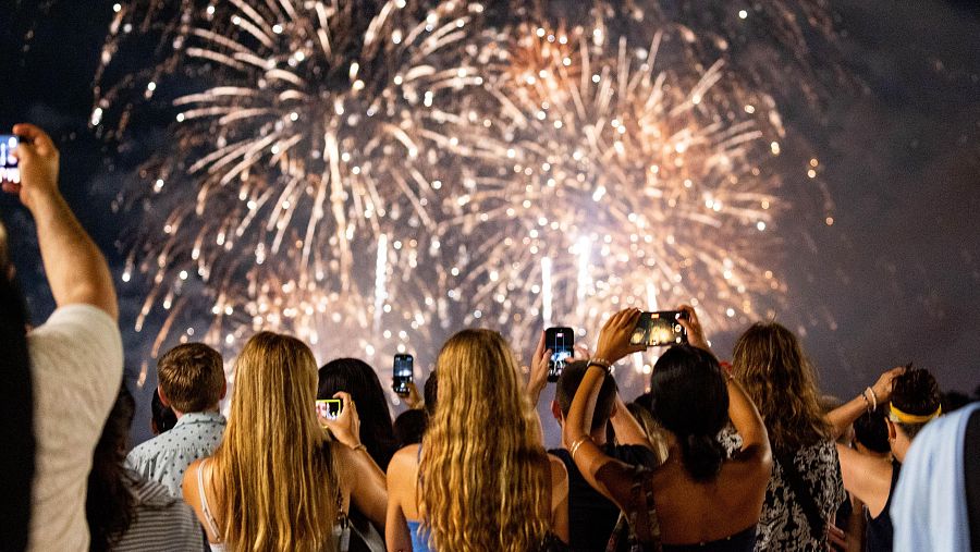 Un grupo de personas graba con su móviles los fuegos artificiales