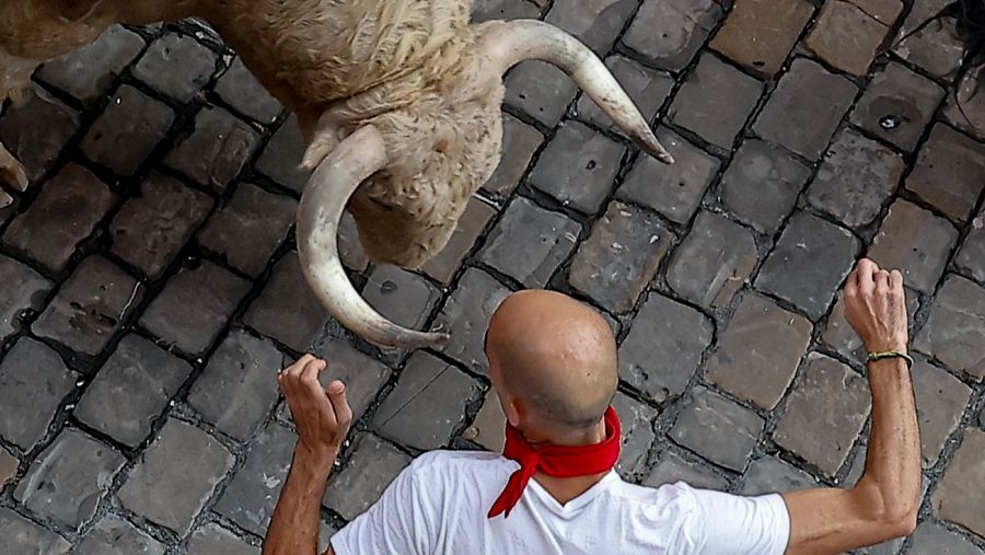 Un mozo ante uno de los toros a su paso por la Plaza Consistorial