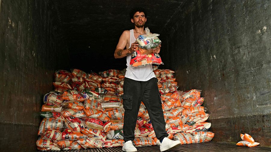 Un hombre descarga alimentos no perecederos de un camión en Caraballeda, estado de La Guaira (Venezuela), el 10 de julio de 2026, tras los dos terremotos registrados el 24 de junio.