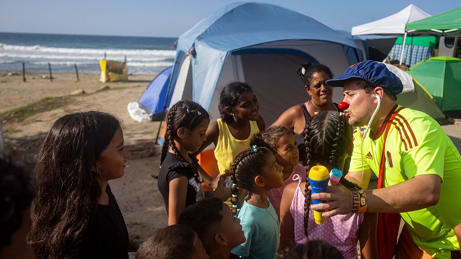 Un hombre disfrazado de payaso, frente a niños, participa en una actividad recreativa para damnificados por los terremotos del pasado 24 de junio.