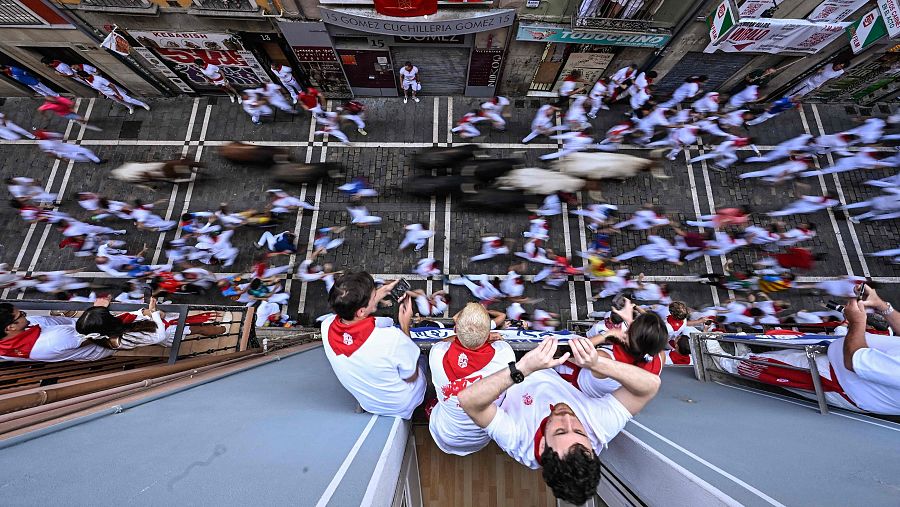 La gente observa desde los balcones cómo los participantes corren delante de los toros de la Jandilla