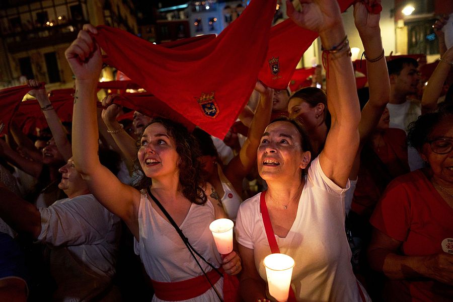 Pamplonicas sostienen velas y pañuelos rojos mientras cantan 'Pobre de Mí'