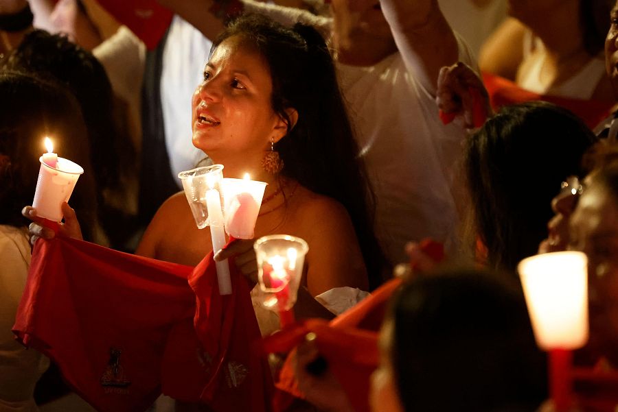 Una pamplonica porta varias velas y el pañuelo al cantar el pobre de mí