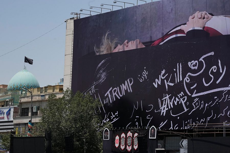 Valla publicitaria que muestra a Trump acostado sobre lo que parece ser un ataúd, en la plaza de la República Islámica de Teherán