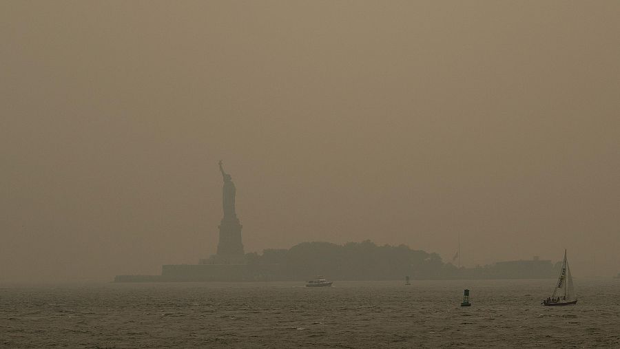La neblina provocada por los incendios forestales canadienses cubre la Estatua de la Libertad, en esta foto tomada desde un ferry de Staten Island