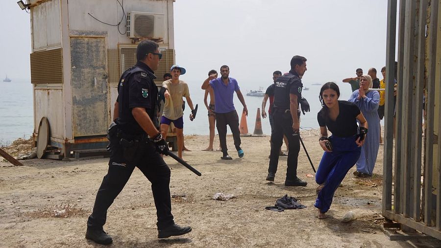 Armados con palos, agentes de la Policía intentan frenar la llegada de inmigrantes