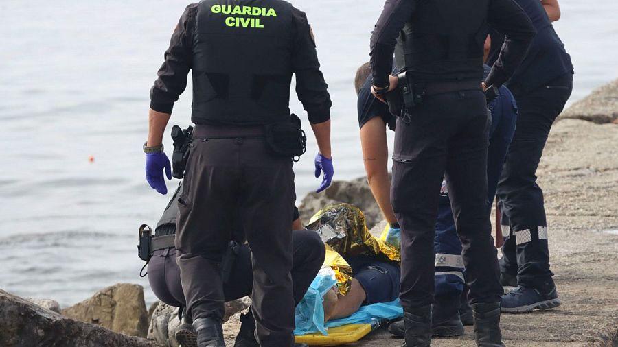 La Guardia Civil atiende a un migrante al lado del mar. En los últimos 12 meses han fallecido 60 personas en el mar