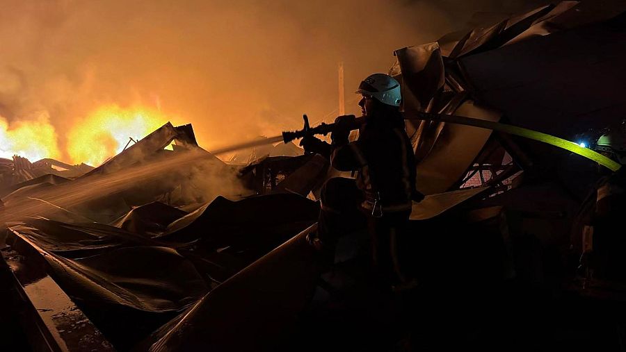 Los equipos de rescate trabajan en las inmediaciones de un almacén dañado tras los ataques masivos rusos en Kiev