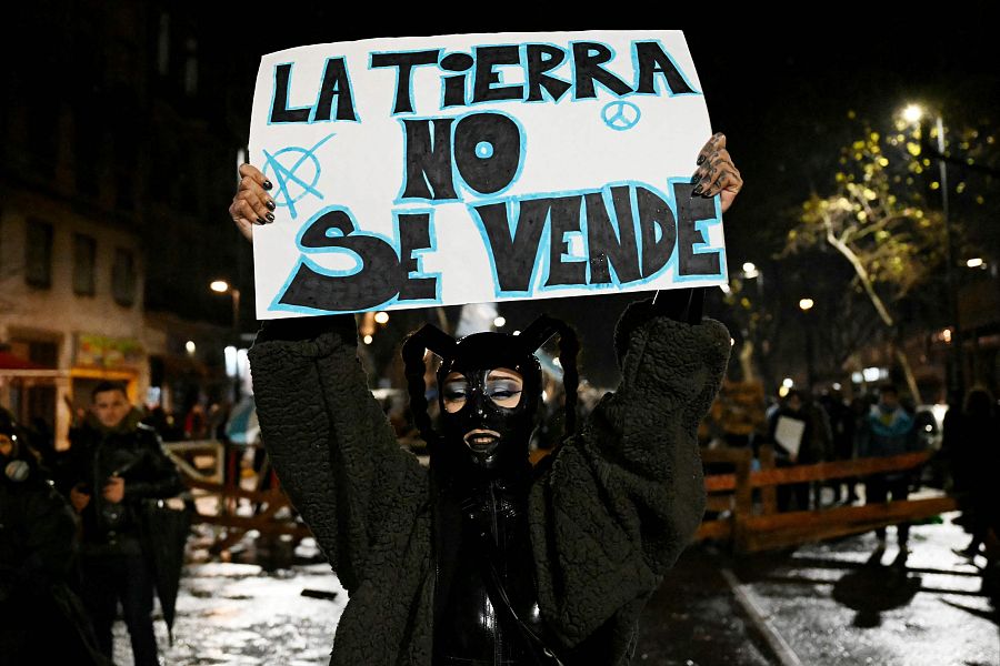 Una manifestante muestra un cartel que dice 